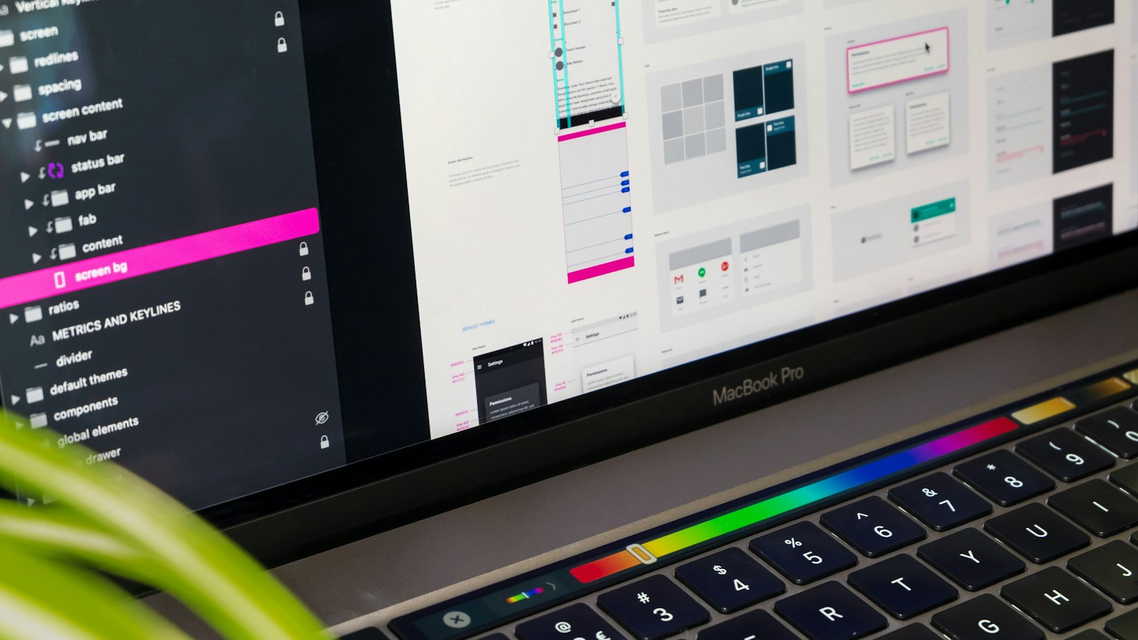 Laptop med webbdesign och layoutskisser på skärmen