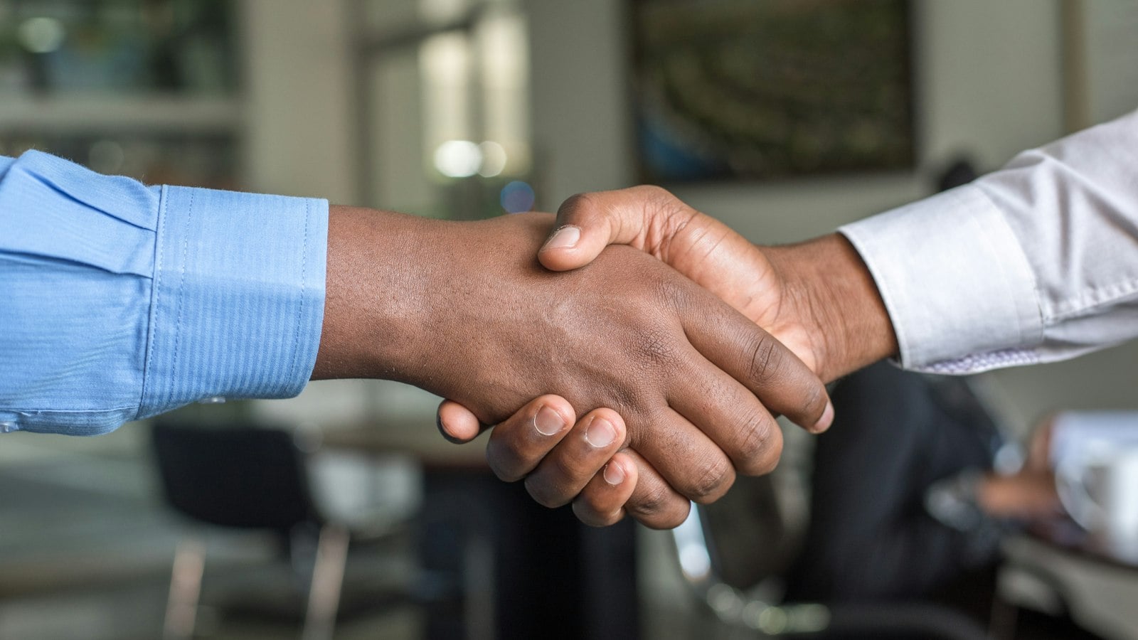 Two people shaking hands in a meeting